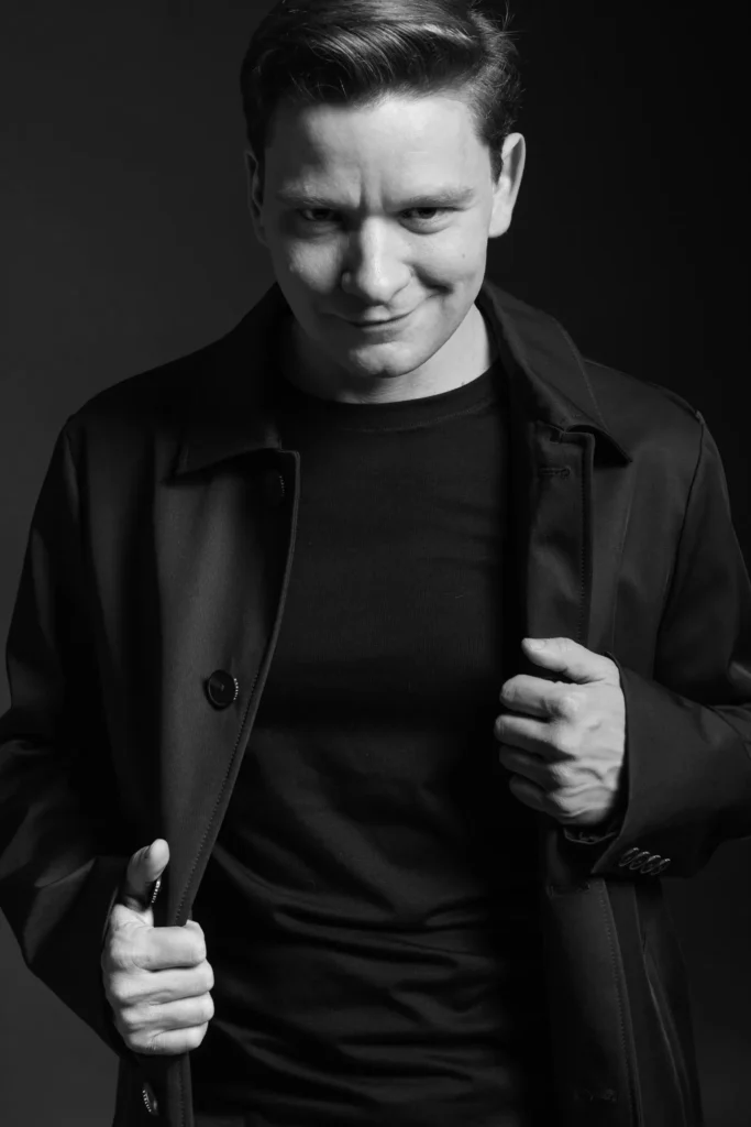 Portfolio aktorskie - portret młodego mężczyzny aktora czarno - biały. Mężczyzna aktor - spogląda niepokojąco do kamery Fotograf Natalia Rakowska